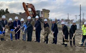 Members of the Paiva family, Bowerman Construction, the City of East Providence scoop the first pile of ceremonial dirt at the groundbreaking of Paiva Plaza 